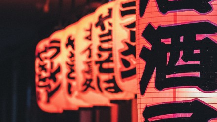 Illuminated paper lanterns with Japanese writing on them at night